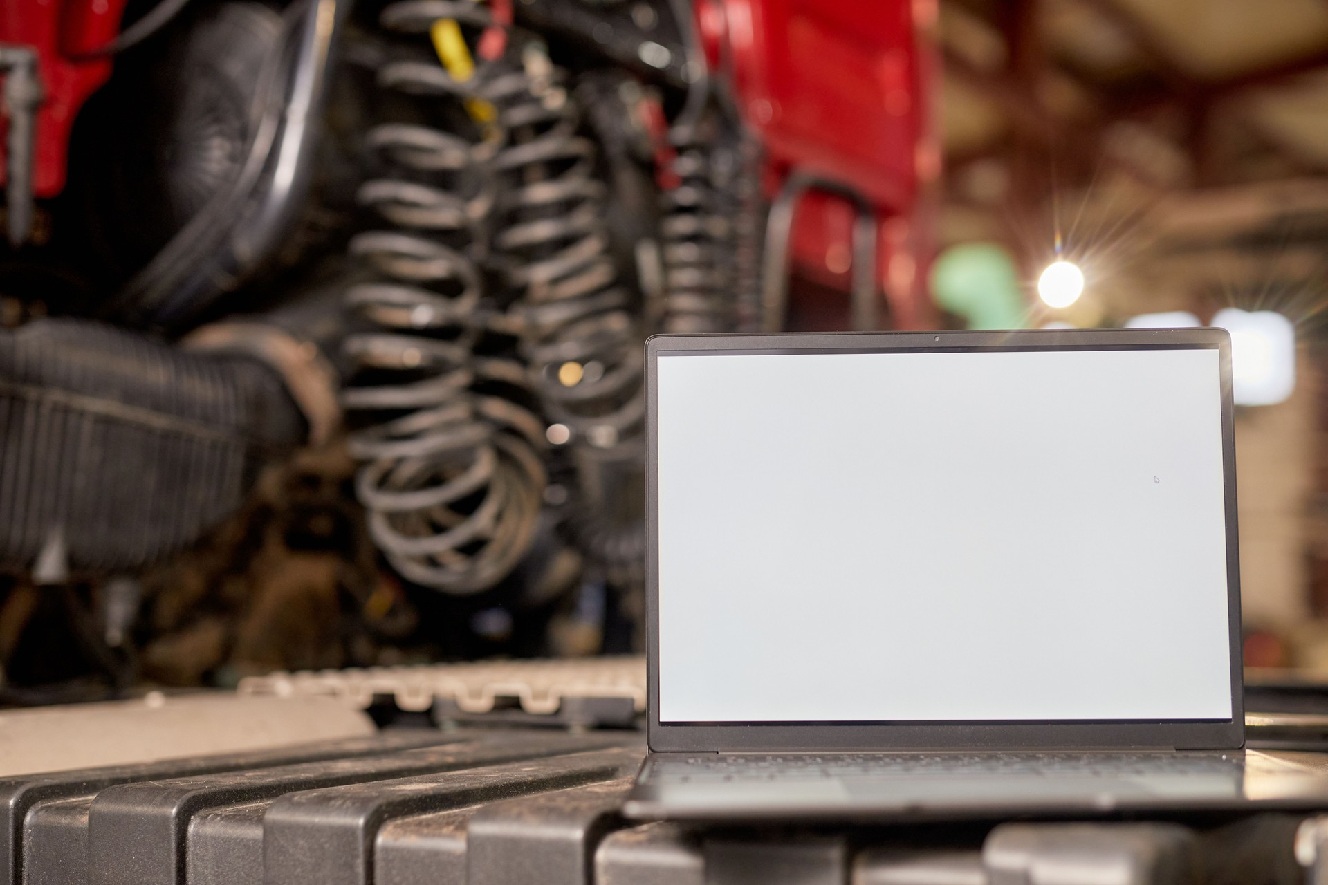 Displaying Open Laptop Next to Heavy Machinery in Workshop